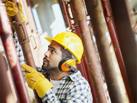 latin american construction worker fastening girder. Side view Stock Photo - Budget Royalty-Free & Subscription, Code: 400-04151365