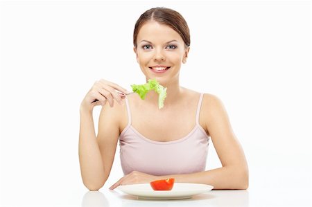 salad fork and spoon - Smiling girl eats the leaf of salad isolated Stock Photo - Budget Royalty-Free & Subscription, Code: 400-04151626