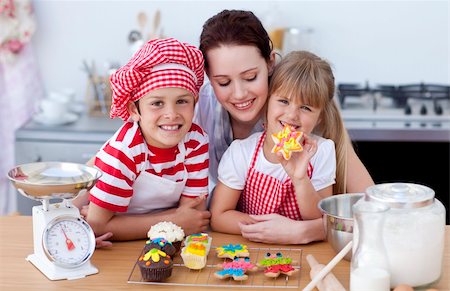 simsearch:695-05773760,k - Smiling young mother and children baking in the kitchen Photographie de stock - Aubaine LD & Abonnement, Code: 400-04151954