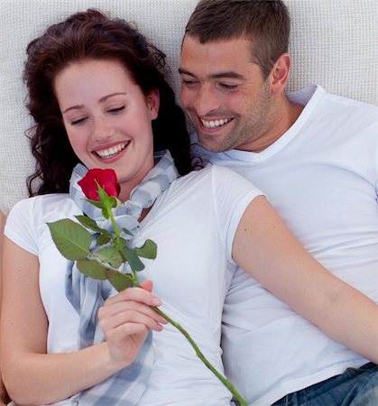 simsearch:400-04151970,k - Lovely couple on sofa, woman holding a rose Fotografie stock - Microstock e Abbonamento, Codice: 400-04151978