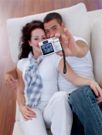 simsearch:400-04151970,k - Happy couple playing with a camera in living-room Fotografie stock - Microstock e Abbonamento, Codice: 400-04151970