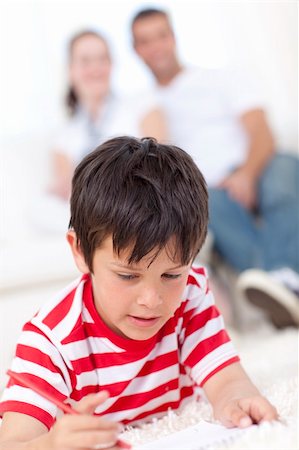 simsearch:400-04198769,k - Smiling kid drawing on floor in living-room with his parents on sofa Foto de stock - Super Valor sin royalties y Suscripción, Código: 400-04152018