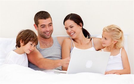 Parents and children using a laptop in bed Stock Photo - Budget Royalty-Free & Subscription, Code: 400-04152087