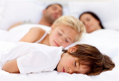 Children sleeping with his parents in a big bed Stock Photo - Budget Royalty-Free & Subscription, Code: 400-04152120