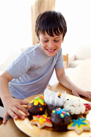 Happy boy looking at colorful confectionery at home Stock Photo - Budget Royalty-Free & Subscription, Code: 400-04152138