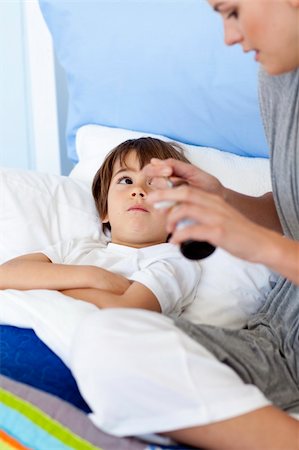 simsearch:400-05749823,k - Mother giving her son lying in bed syrup because of the flu Foto de stock - Super Valor sin royalties y Suscripción, Código: 400-04152157