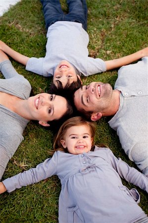 Happy family lying in a garden with heads together Photographie de stock - Aubaine LD & Abonnement, Code: 400-04152151