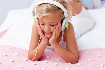 simsearch:400-05717354,k - Little girl in bed with a headphones on listening to the music Stock Photo - Budget Royalty-Free & Subscription, Code: 400-04152169