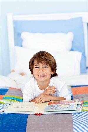 simsearch:400-06747549,k - Smiling little boy reading a book in bed Foto de stock - Super Valor sin royalties y Suscripción, Código: 400-04152172