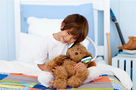 simsearch:400-04196952,k - Little boy playing with headphones and teddy bear on bed Foto de stock - Royalty-Free Super Valor e Assinatura, Número: 400-04152184