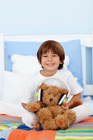 simsearch:400-04196952,k - Happy kid playing with headphones and teddy bear on bed Foto de stock - Royalty-Free Super Valor e Assinatura, Número: 400-04152185