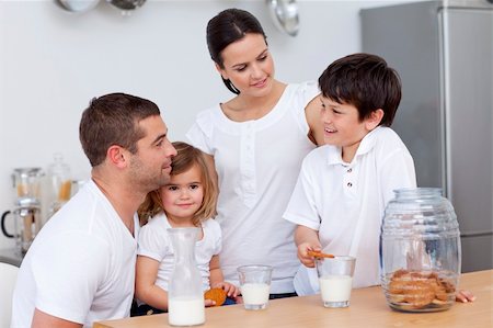 simsearch:400-04416091,k - Parents and children eating biscuits and drinking milk in the kitchen Fotografie stock - Microstock e Abbonamento, Codice: 400-04152201