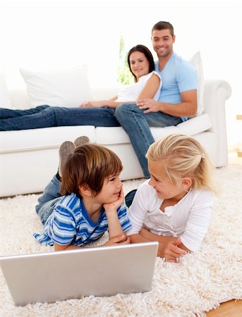 simsearch:400-04575374,k - Friends using a laptop on floor and couple lying on sofa Stock Photo - Budget Royalty-Free & Subscription, Code: 400-04152224