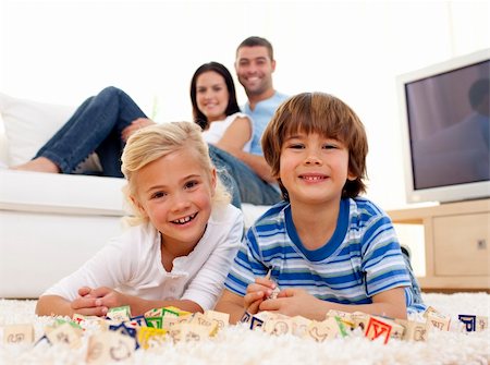 Brother and sister playing with alphabet cubes at home with parents on sofa Stock Photo - Budget Royalty-Free & Subscription, Code: 400-04152239