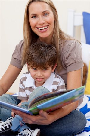 simsearch:400-05751566,k - Smiling motherr reading a book with her son in bedroom Stock Photo - Budget Royalty-Free & Subscription, Code: 400-04152310