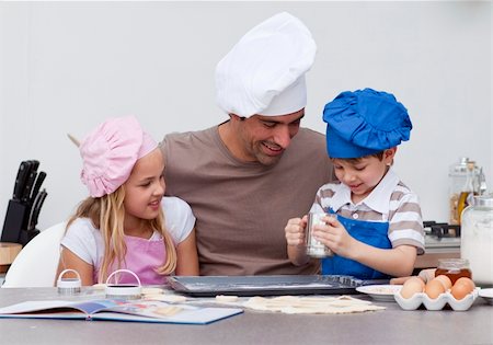 family eating cookies - Smiling father and children baking in the kitchen Stock Photo - Budget Royalty-Free & Subscription, Code: 400-04152324