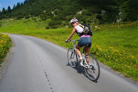 peterkirillov (artist) - Girl riding fast on a bicycle in mountain area. Back view Fotografie stock - Microstock e Abbonamento, Codice: 400-04153137