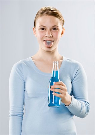 Young girl with blue tongue holding bottle of blue liquid.  Vertically framed shot. Stock Photo - Budget Royalty-Free & Subscription, Code: 400-04167381