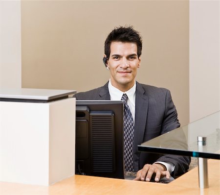 simsearch:400-04167547,k - Young man in suit sitting at desk.  Horizontally framed shot. Stock Photo - Budget Royalty-Free & Subscription, Code: 400-04167445