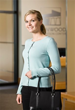 simsearch:6108-05867864,k - Young woman with purse standing.  Vertically framed shot. Stockbilder - Microstock & Abonnement, Bildnummer: 400-04167459