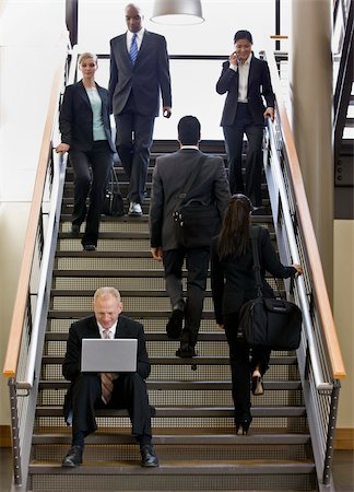 Businessman sitting on busy stairs with laptop.  Vertically framed shot. Stock Photo - Budget Royalty-Free & Subscription, Code: 400-04167497