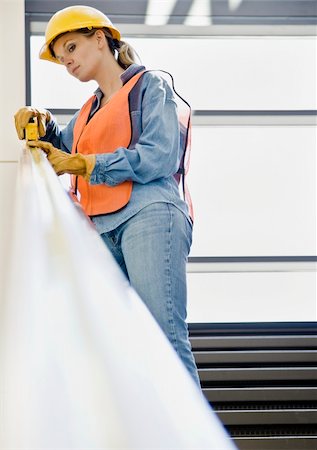 simsearch:400-04167547,k - Female construction worker taking measurement with measuring tape.  Vertically framed shot. Stock Photo - Budget Royalty-Free & Subscription, Code: 400-04167529