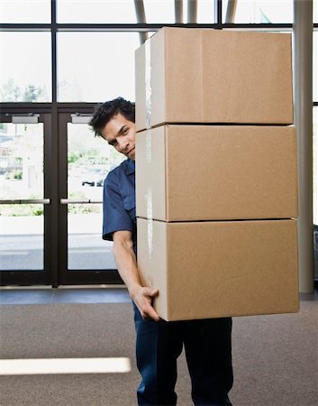 simsearch:400-04167547,k - Young man delivering boxes.  Vertically framed shot. Stock Photo - Budget Royalty-Free & Subscription, Code: 400-04167543
