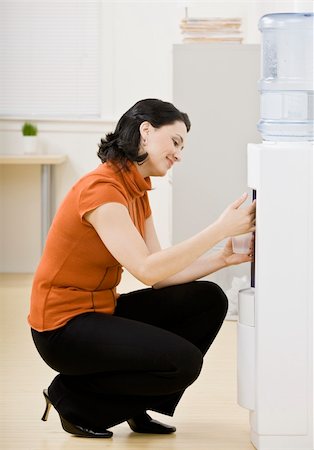 Business woman at water cooler. Vertically framed shot. Stock Photo - Budget Royalty-Free & Subscription, Code: 400-04167631