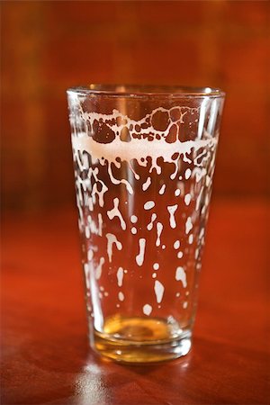 simsearch:400-04167893,k - Empty beer glass on bar counter with residual foam lining the glass. Vertical shot. Stockbilder - Microstock & Abonnement, Bildnummer: 400-04167896
