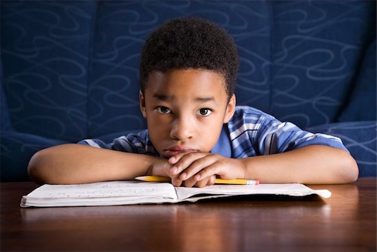 Young African American boy sits on the floor at a coffee table. He is looking towards the camera with his homework on the table. Horizontal shot. Photographie de stock - Libre de Droits (LD), Artiste: iofoto, Le code de l’image : 400-04168199
