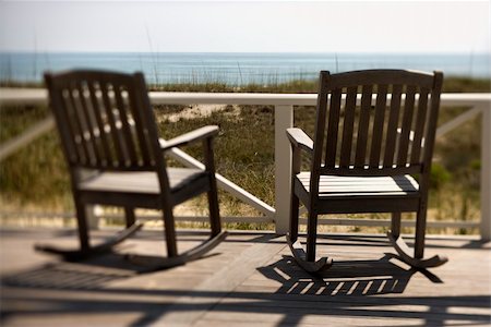 Two wooden rocking chairs sitting on a deck. They are facing the shore. Horizontal shot. Stock Photo - Budget Royalty-Free & Subscription, Code: 400-04168269