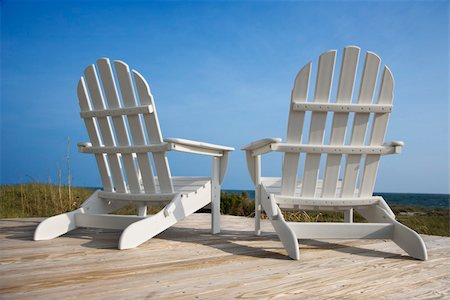 simsearch:400-03923118,k - Rear view of two white Adirondack style chairs sitting on a wooden deck, facing the beach. Vertical shot. Fotografie stock - Microstock e Abbonamento, Codice: 400-04168276