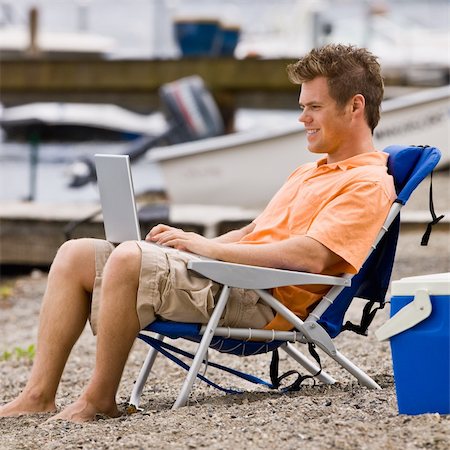 Man using laptop on beach Stock Photo - Budget Royalty-Free & Subscription, Code: 400-04168559