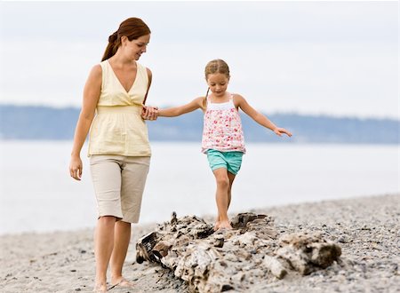 Mother helping daughter walk on log at beach Stock Photo - Budget Royalty-Free & Subscription, Code: 400-04168674