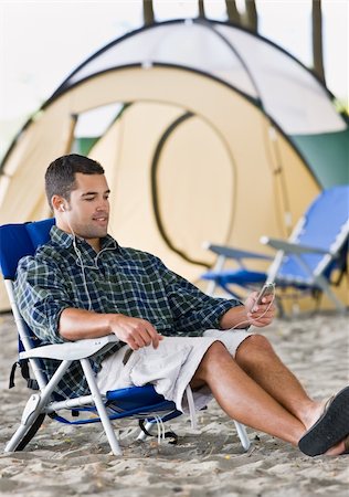 simsearch:400-04168729,k - Man using mp3 player at campsite Stock Photo - Budget Royalty-Free & Subscription, Code: 400-04168695