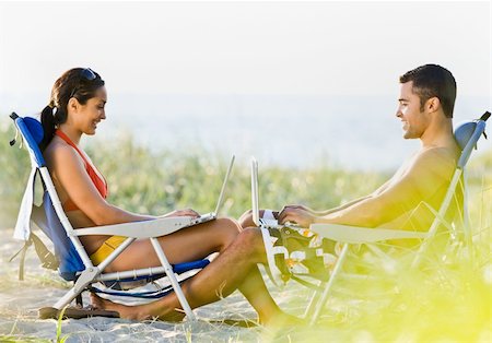 simsearch:400-04168729,k - Couple using laptops at beach Stock Photo - Budget Royalty-Free & Subscription, Code: 400-04168744