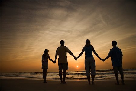 family holding hands on beach at sundown - Silhouette of family holding hands on beach watching the sunset. Horizontally framed shot. Stock Photo - Budget Royalty-Free & Subscription, Code: 400-04168814