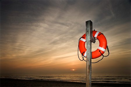 Life Preserver on pole at beach at sunset.  Horizontally framed shot. Stock Photo - Budget Royalty-Free & Subscription, Code: 400-04168812