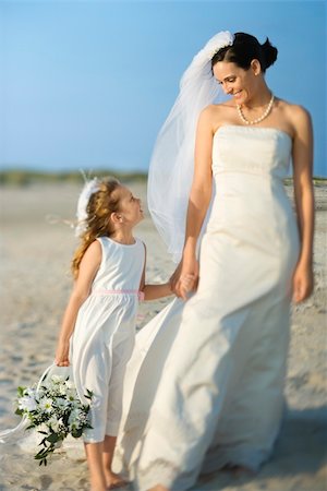 Bride and a flower girl hold hands on a sandy beach. Horizontal shot. Stock Photo - Budget Royalty-Free & Subscription, Code: 400-04168842