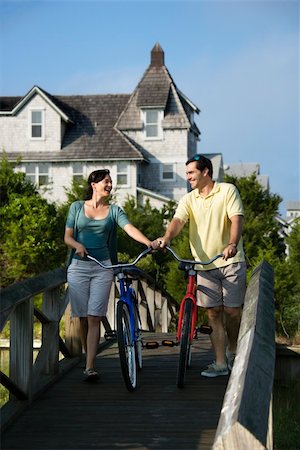 Smiling couple walking bikes across a bridge.  Vertical shot. Stock Photo - Budget Royalty-Free & Subscription, Code: 400-04168885
