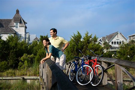 Man and woman leaning and relaxing on a bridge railing with their bikes. Horizontal shot. Stockbilder - Microstock & Abonnement, Bildnummer: 400-04168886