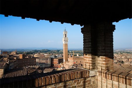 palazzo publico - High angle view of Piazza del Campo and surrounding buildings in Siena, Italy, seen from a covered rooftop vantage point. Horizontal shot. Foto de stock - Super Valor sin royalties y Suscripción, Código: 400-04169017