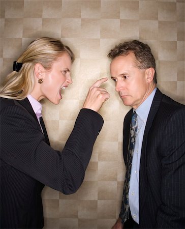 Caucasian mid-adult businesswoman yelling and pointing at middle-aged businessman. Vertical format. Stock Photo - Budget Royalty-Free & Subscription, Code: 400-04169160