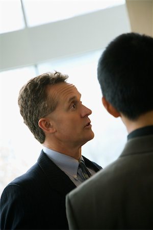 simsearch:400-04167566,k - Cropped view of a Caucasian middle-aged businessman and a young adult businessman in a discussion. Vertical format. Stockbilder - Microstock & Abonnement, Bildnummer: 400-04169190