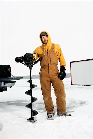 pêche dans la glace - Young man in snow gear poses with an ice drill in a winter environment. Vertical shot. Photographie de stock - Aubaine LD & Abonnement, Code: 400-04169299