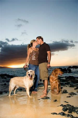 sunrise sea dog - A man and woman hold the leashes of their dogs as they kiss on a beach. Vertical format. Stock Photo - Budget Royalty-Free & Subscription, Code: 400-04169293