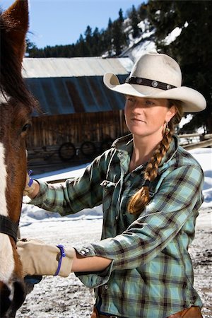 Attractive young woman wearing a cowboy hat and petting a horse. Vertical shot. Stock Photo - Budget Royalty-Free & Subscription, Code: 400-04169379