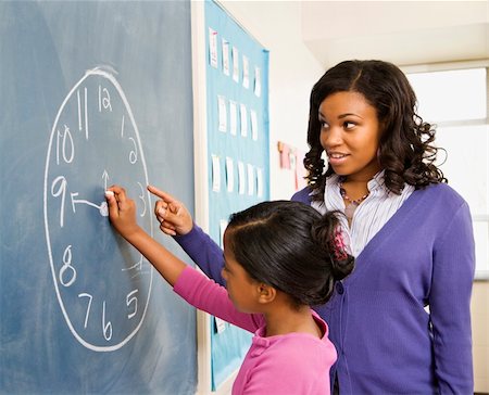 Teacher and female student at the blackboard with clock drawing on it. Photographie de stock - Aubaine LD & Abonnement, Code: 400-04169517