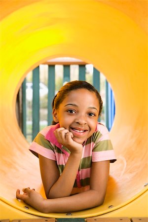 Young girl lying in yellow crawl tube at playground and smiling. Stock Photo - Budget Royalty-Free & Subscription, Code: 400-04169552