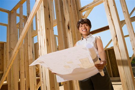 Woman holding blueprints on construction site. Horizontally framed shot. Stock Photo - Budget Royalty-Free & Subscription, Code: 400-04169583